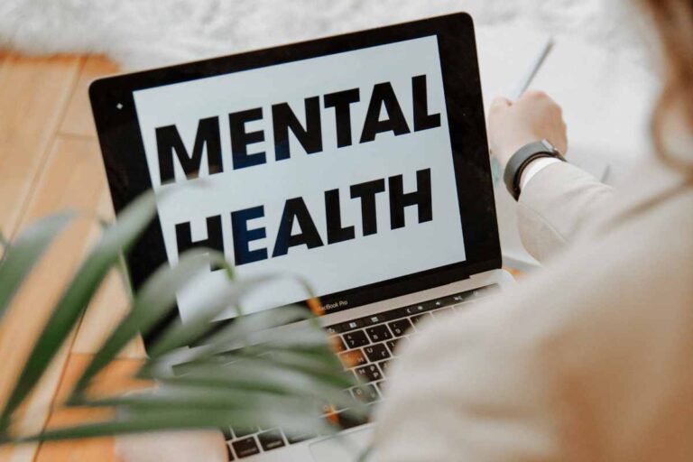 una persona fa una ricerca online e scritta mental health sullo schermo