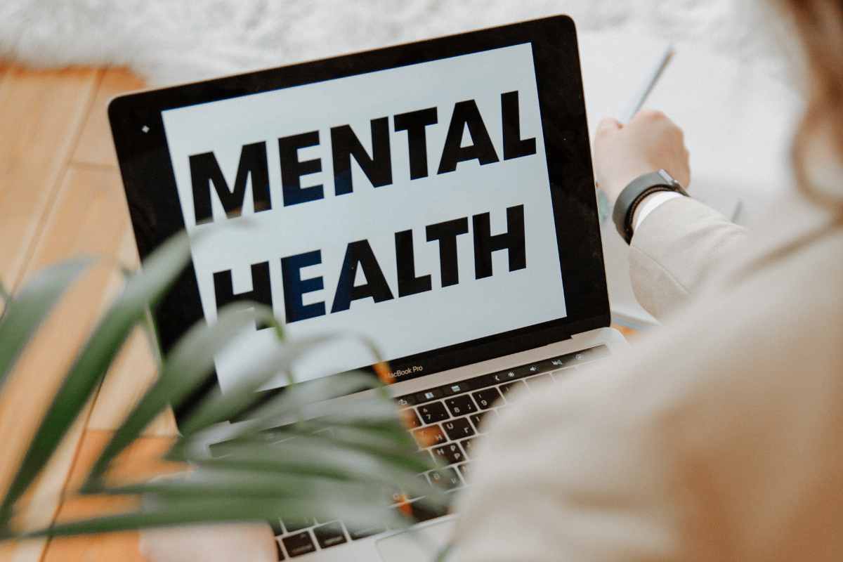 una persona fa una ricerca online e scritta mental health sullo schermo